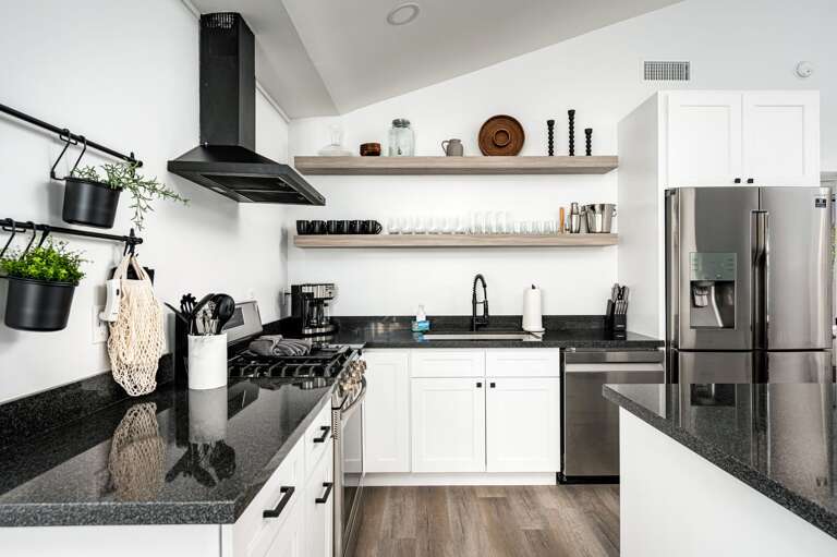Stainless steel appliances and fully stocked cookware.