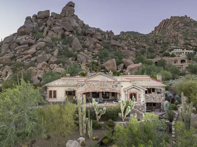 Discover a luxurious desert retreat nestled among dramatic rock formations, offering breathtaking mountain views and stunning natural surroundings.