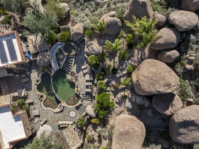 Discover a luxurious desert retreat nestled among dramatic rock formations, offering breathtaking mountain views and stunning natural surroundings.