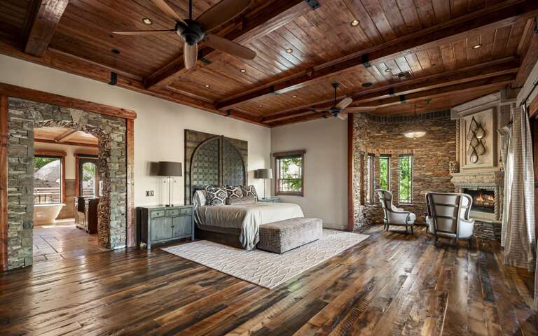 Retreat to the luxurious primary suite, featuring rich wood accents, a cozy fireplace, and a private