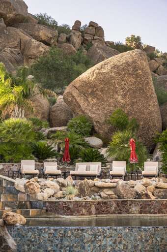 Enjoy a luxurious outdoor retreat featuring a stunning pool, waterslide, and inviting poolside seating.