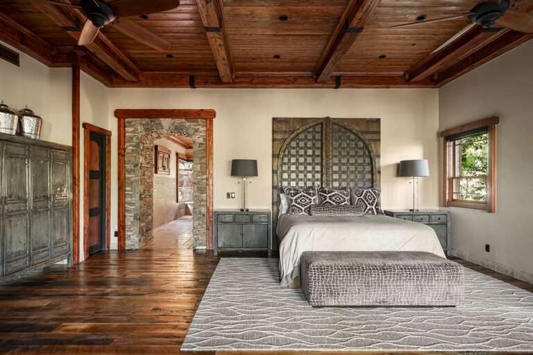 Retreat to the luxurious primary suite, featuring rich wood accents, a cozy fireplace, and a private