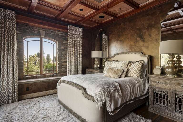 Unwind in this elegant bedroom featuring rich wood accents, plush furnishings, and beautiful desert