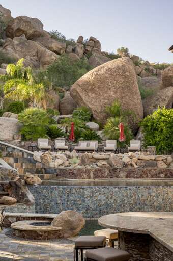 Enjoy a luxurious outdoor retreat featuring a stunning pool, waterslide, and inviting poolside seating.