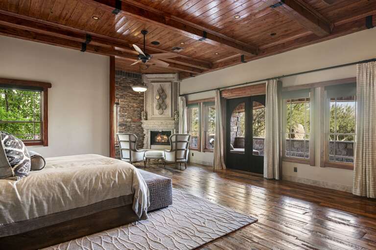Retreat to the luxurious primary suite, featuring rich wood accents, a cozy fireplace, and a private