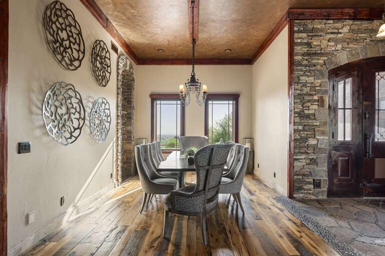 Gather around the elegant dining table, surrounded by rich hardwood floors, sophisticated finishes, and beautiful desert views.