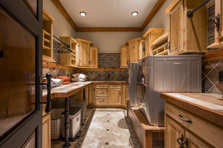 A spacious laundry room featuring a full-size washer and dryer, generous cabinetry, and ample counter space for added convenience during your stay.