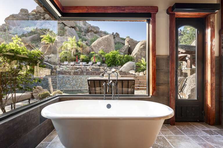 Indulge in the luxurious primary bathroom, featuring a spacious walk-in shower, dual vanities, and a