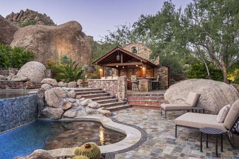 Relax poolside with luxurious loungers, stunning desert scenery, and a charming covered outdoor bar.
