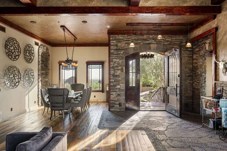 Step into timeless elegance with a grand stone entryway, rich wood accents, and a beautifully appointed dining area.