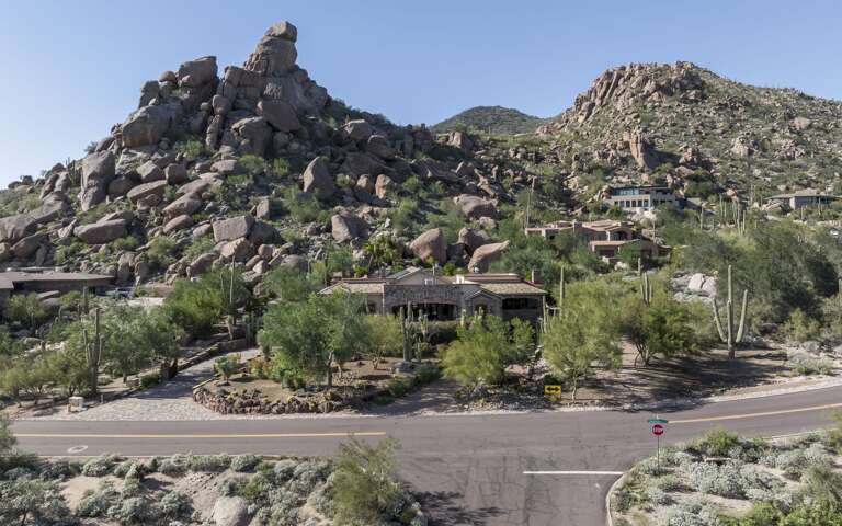 Discover a luxurious desert retreat nestled among dramatic rock formations, offering breathtaking mountain views and stunning natural surroundings.