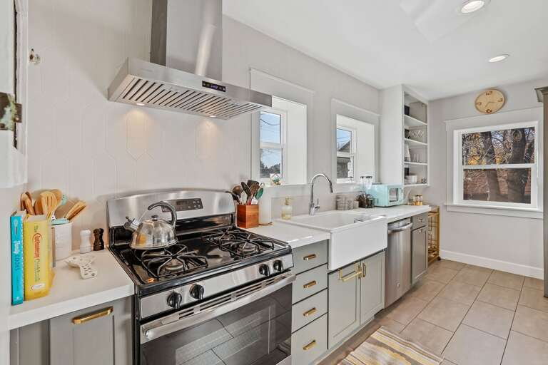 The kitchen features a gas stove, retro microwave, stainless steel appliances, and a charming farmhouse sink. The kitchen features a gas stove, retro microwave, stainless steel appliances, and a charming farmhouse sink.