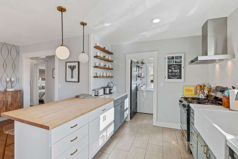 The kitchen features a gas stove, retro microwave, stainless steel appliances, and a charming farmhouse sink. The kitchen features a gas stove, retro microwave, stainless steel appliances, and a charming farmhouse sink.