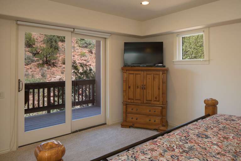 Bedroom 3: King-sized bed, flat-screen TV, and private balcony access (includes a twin cot for extra sleeping options). Bedroom 3: King-sized bed, flat-screen TV, and private balcony access (includes a twin cot for extra sleeping options).