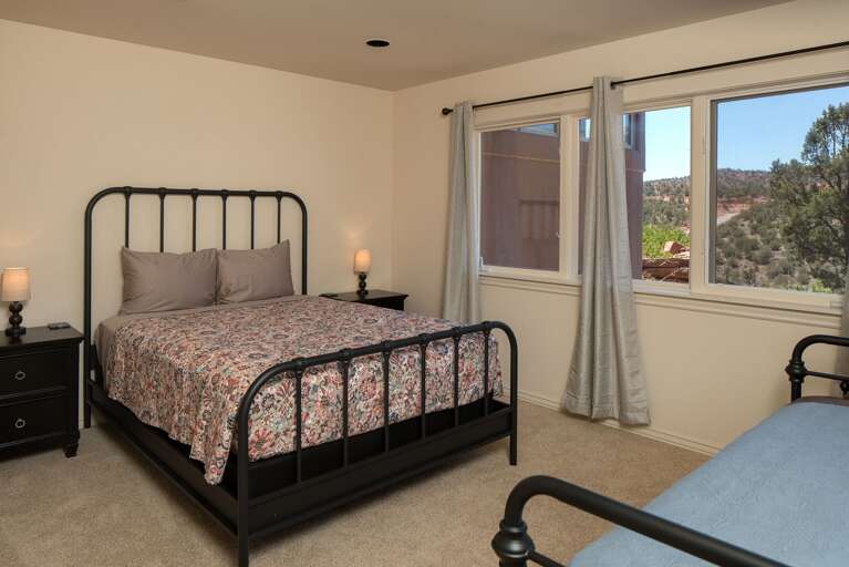 This cozy bedroom offers a queen-sized bed and a twin single, perfect for a family or friends. This cozy bedroom offers a queen-sized bed and a twin single, perfect for a family or friends.
