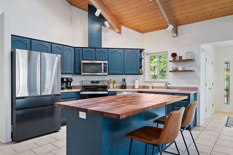 Fully Equipped Chef's Kitchen: Modern appliances, deep blue cabinetry, and a large butcher block island for whipping up your favorite meals. Fully Equipped Chef's Kitchen: Modern appliances, deep blue cabinetry, and a large butcher block island for whipping up your favorite meals.