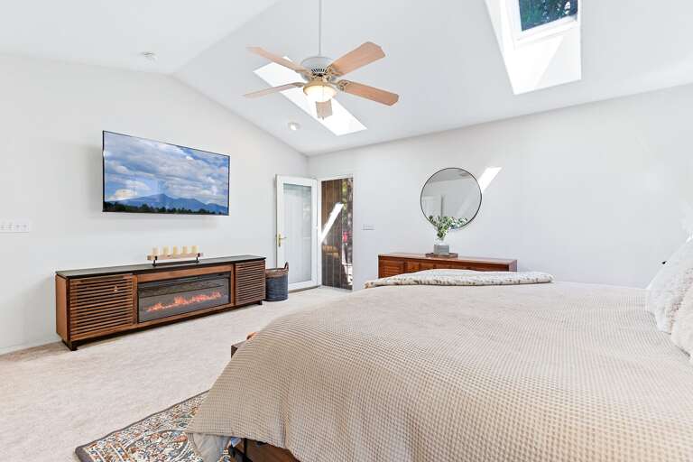 Primary Suite: King-size bed, media center with an electric fireplace, private backyard access, and en suite with jetted bathtub, dual vanity, and walk-in closet. Primary Suite: King-size bed, media center with an electric fireplace, private backyard access, and en suite with jetted bathtub, dual vanity, and walk-in closet.