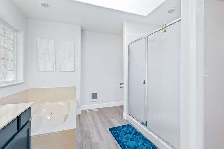 Primary Suite: King-size bed, media center with an electric fireplace, private backyard access, and en suite with jetted bathtub, dual vanity, and walk-in closet. Primary Suite: King-size bed, media center with an electric fireplace, private backyard access, and en suite with jetted bathtub, dual vanity, and walk-in closet.