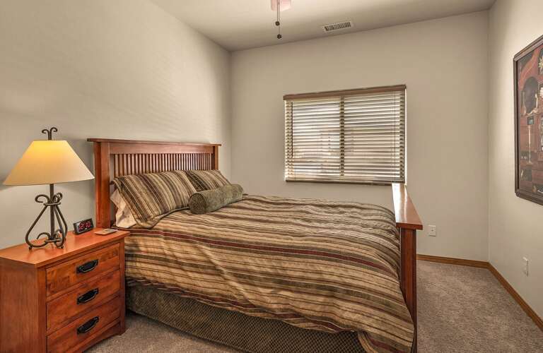 Guest Bedroom 2: spacious room with Queen bed, clothing storage and ceiling fan for added ambiance.