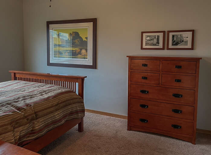 Guest Bedroom 2: spacious room with Queen bed, clothing storage and ceiling fan for added ambiance.