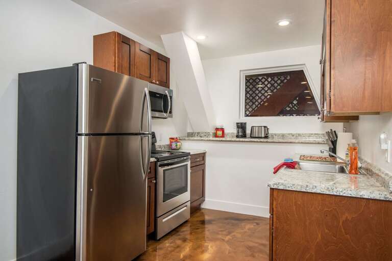 Fully Equipped Kitchen – Compact but stylish with all the essentials, including a fridge/freezer, stove, and microwave, paired with stainless steel appliances and granite countertops.