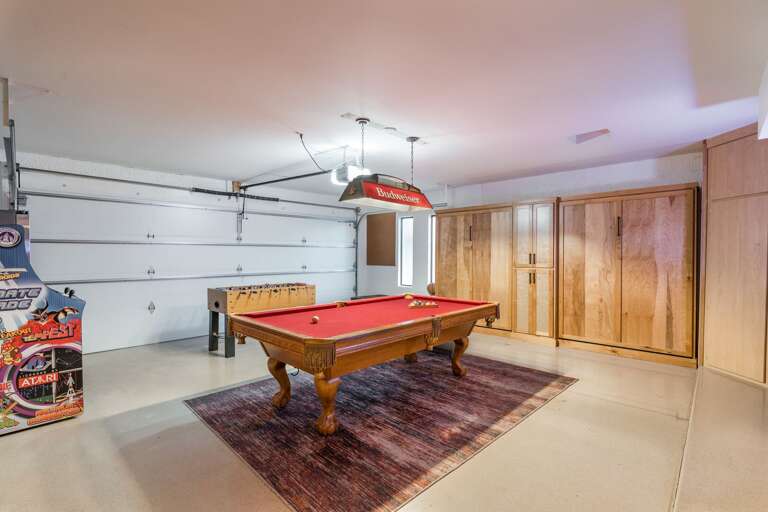 Spacious Garage With Red Pool Table, Rustic Cabinets, And Pinball Machine Spacious Garage With Red Pool Table, Rustic Cabinets, And Pinball Machine