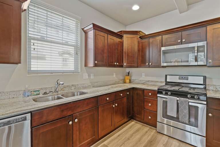 Create memorable meals in this fully equipped kitchen featuring premium appliances, dark wood cabinets, and ample counter space. Create memorable meals in this fully equipped kitchen featuring premium appliances, dark wood cabinets, and ample counter space.