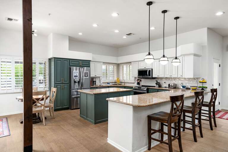 Kitchen includes breakfast table and barstool seating