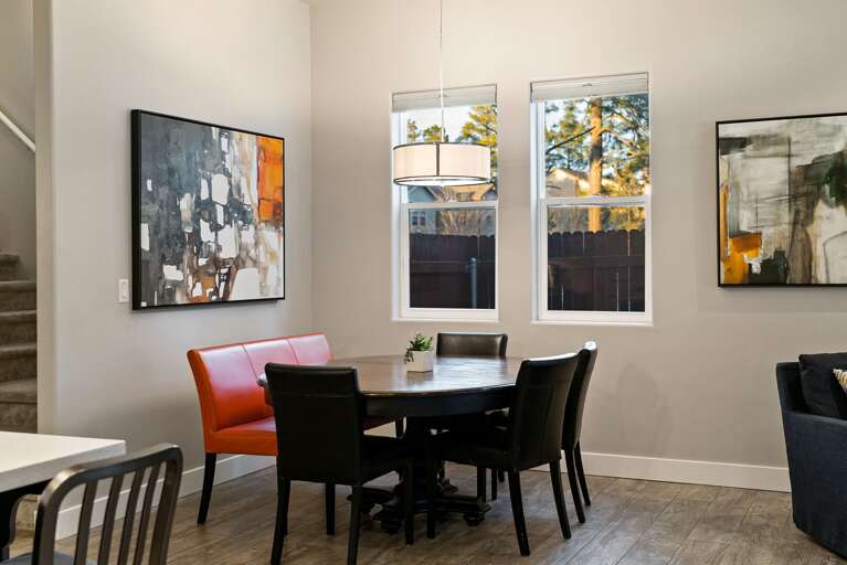 Dining area with bench seating and chairs seating 7, perfect for shared meals.