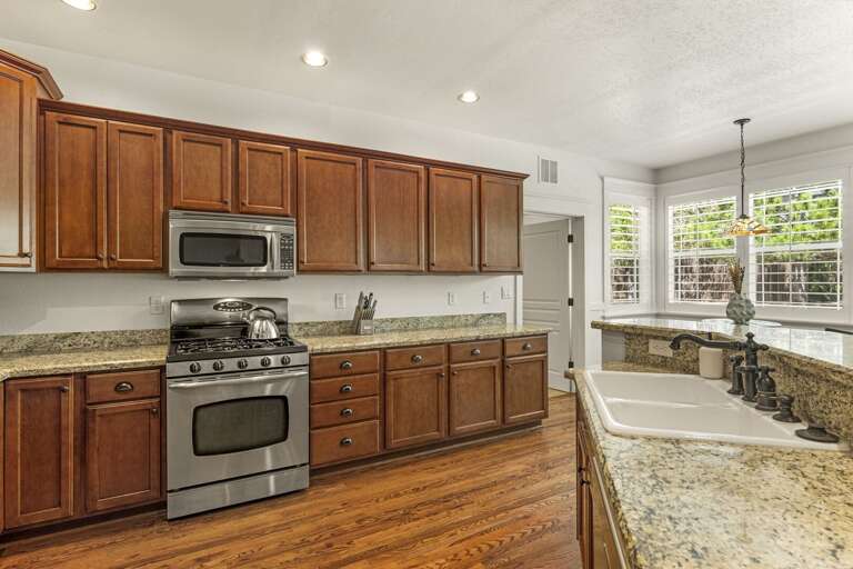 The kitchen features top-of-the-line stainless-steel appliances and granite countertops, with seating options for group meals. The kitchen features top-of-the-line stainless-steel appliances and granite countertops, with seating options for group meals.