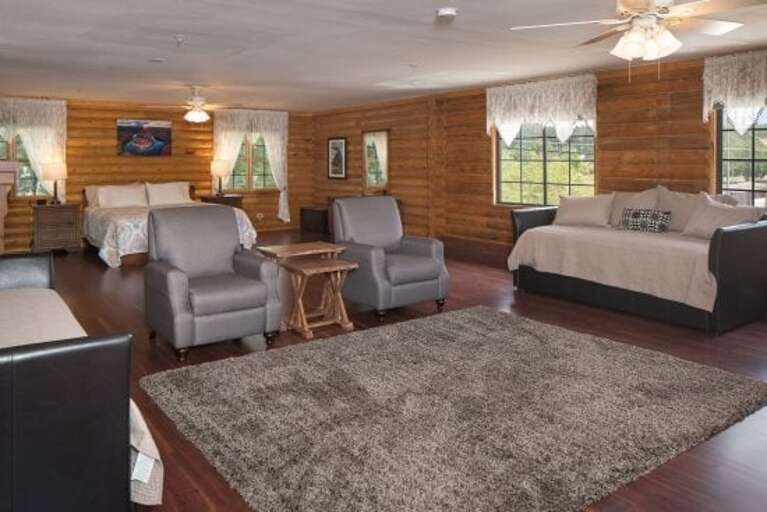 Master Bedroom with two chairs and view of one of the twin trundle beds.