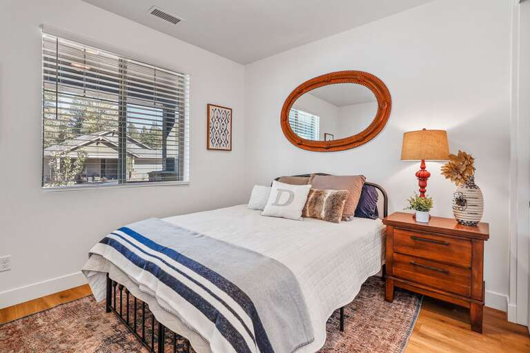 To your left, you'll find the first bedroom, featuring a cozy queen-sized bed and a flat-screen smart TV. With lovely views of the front yard. To your left, you'll find the first bedroom, featuring a cozy queen-sized bed and a flat-screen smart TV. With lovely views of the front yard.