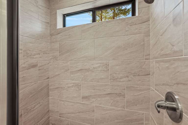 1st Floor Primary Suite 1 (King Bed): En-suite bathroom with dual sinks, walk-in shower, and private toilet room. 1st Floor Primary Suite 1 (King Bed): En-suite bathroom with dual sinks, walk-in shower, and private toilet room.