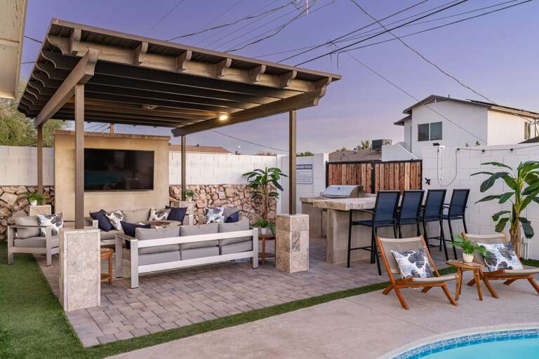 Resort-style Pergola w/ TV, Seating, and Barstool Seating for 4.