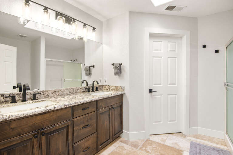 Primary Suite: King-sized bed, smart TV, XL bean bag chair, and en-suite bathroom with dual vanities and a glass shower. Primary Suite: King-sized bed, smart TV, XL bean bag chair, and en-suite bathroom with dual vanities and a glass shower.