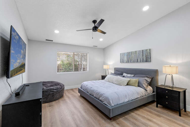 Primary Suite: King-sized bed, smart TV, XL bean bag chair, and en-suite bathroom with dual vanities and a glass shower. Primary Suite: King-sized bed, smart TV, XL bean bag chair, and en-suite bathroom with dual vanities and a glass shower.