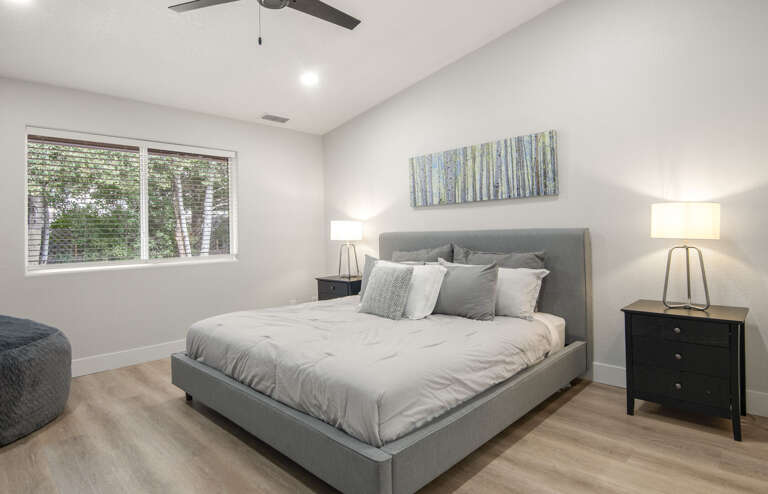Primary Suite: King-sized bed, smart TV, XL bean bag chair, and en-suite bathroom with dual vanities and a glass shower. Primary Suite: King-sized bed, smart TV, XL bean bag chair, and en-suite bathroom with dual vanities and a glass shower.