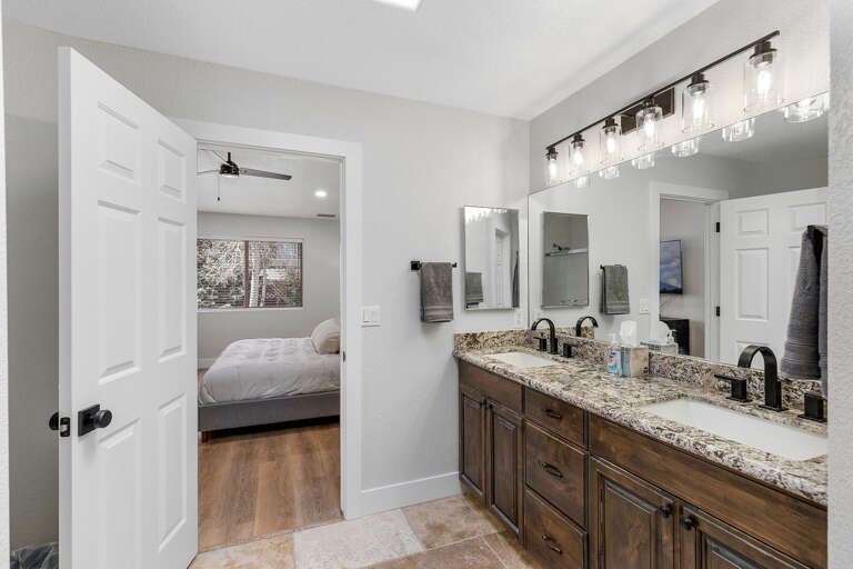 Primary Suite: King-sized bed, smart TV, XL bean bag chair, and en-suite bathroom with dual vanities and a glass shower. Primary Suite: King-sized bed, smart TV, XL bean bag chair, and en-suite bathroom with dual vanities and a glass shower.