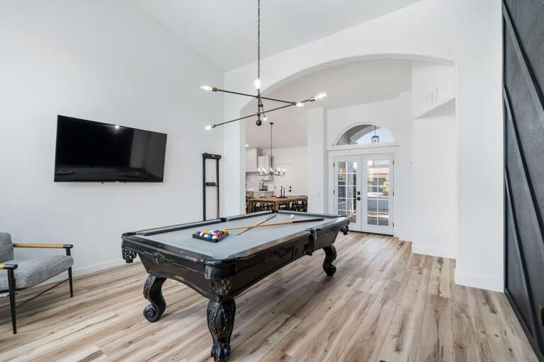 Pool Table w/ Mounted TV & Dining Area in Background Pool Table w/ Mounted TV & Dining Area in Background