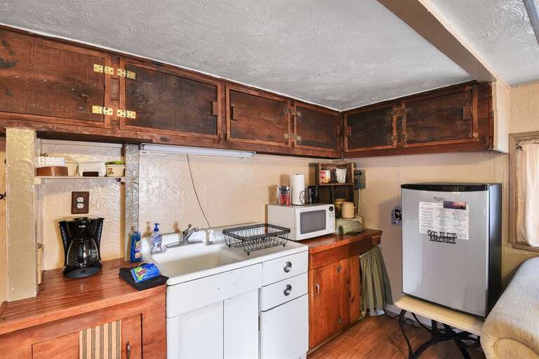 Coffee maker, cooking utensils, dishes, microwave, refrigerator, and toaster.