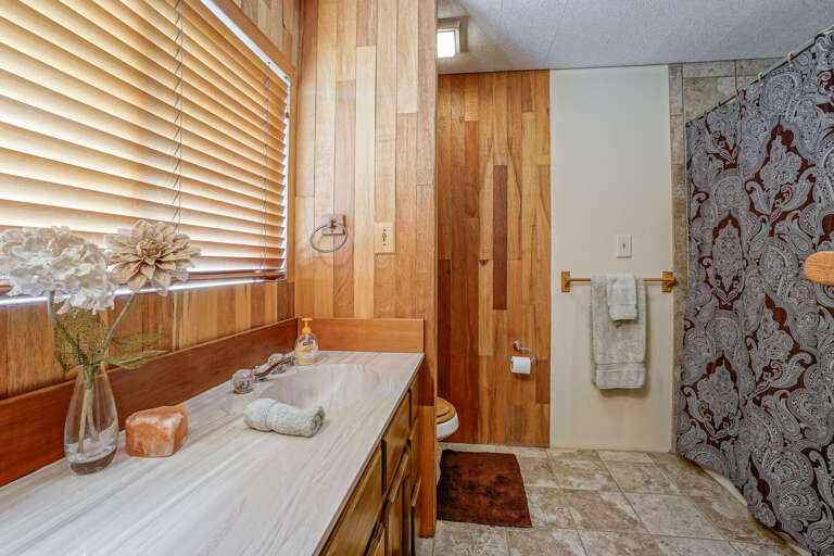 1 Bathroom (Ground Level): Includes double vanity and a tiled walk-in shower with dual shower heads. 1 Bathroom (Ground Level): Includes double vanity and a tiled walk-in shower with dual shower heads.