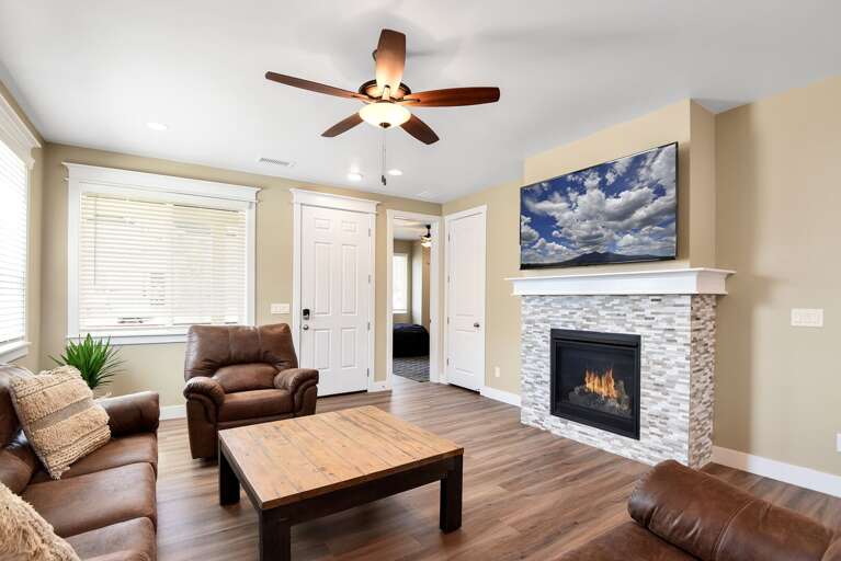 Cozy living room couch and recliners surrounding the fireplace and TV. Cozy living room couch and recliners surrounding the fireplace and TV.