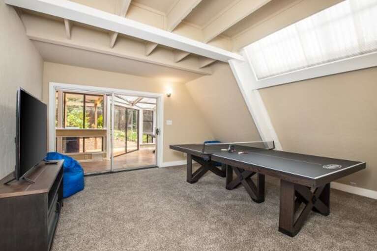 a den with flat-screen television and a Ping Pong Table a den with flat-screen television and a Ping Pong Table