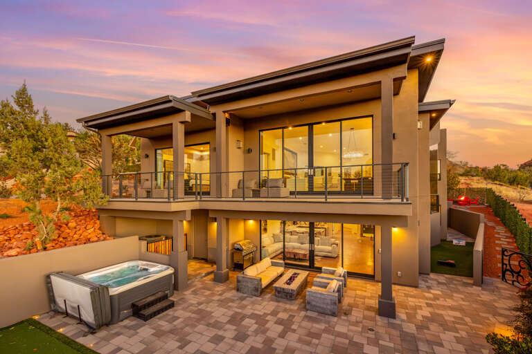Sunset-lit Structure Showcasing Spacious Balconies And A Backyard Hot Tub Sunset-lit Structure Showcasing Spacious Balconies And A Backyard Hot Tub