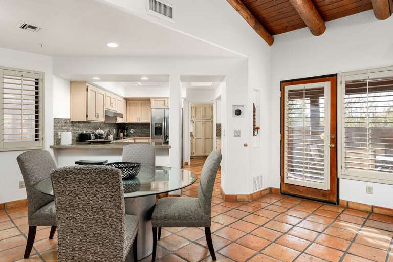 Bright dining space with open kitchen, tile floors, and easy access to the patio.