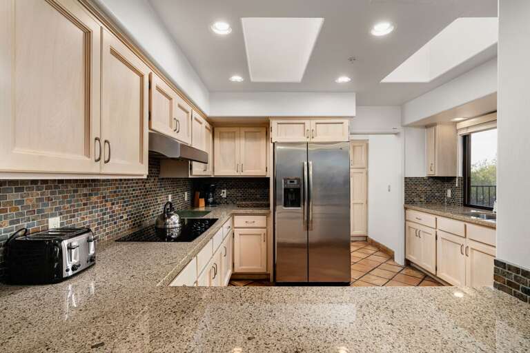 Bright kitchen with granite countertops, stainless appliances, and ample prep space.