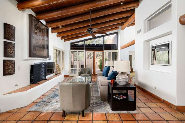 Inviting living room with vaulted wood-beam ceilings, cozy seating, and large windows for natural light.