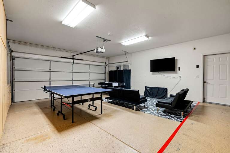 Dedicated game and media room with ping pong table, air hockey table, TV, and space to gather.