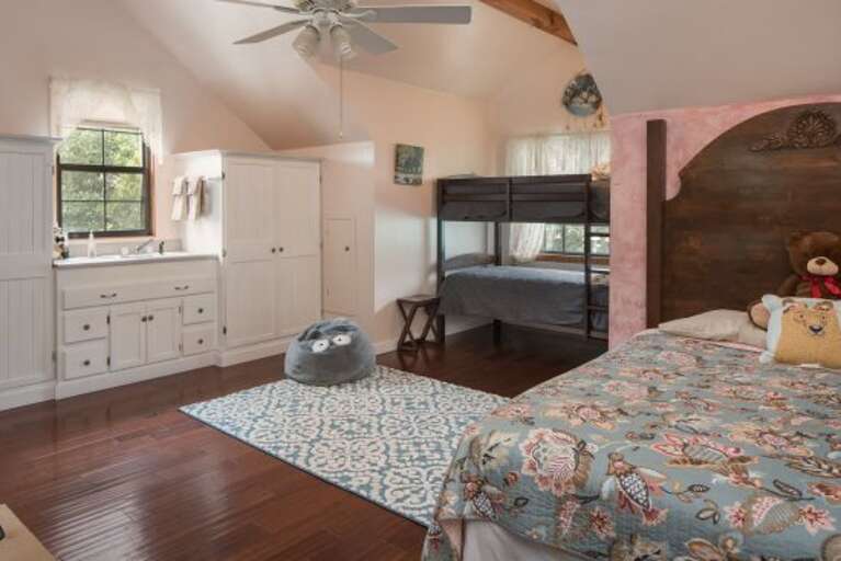 Third Bedroom: A versatile room with a Queen-sized bed, a Twin bunk bed, a TV, and a convenient sink, perfect for families or groups.