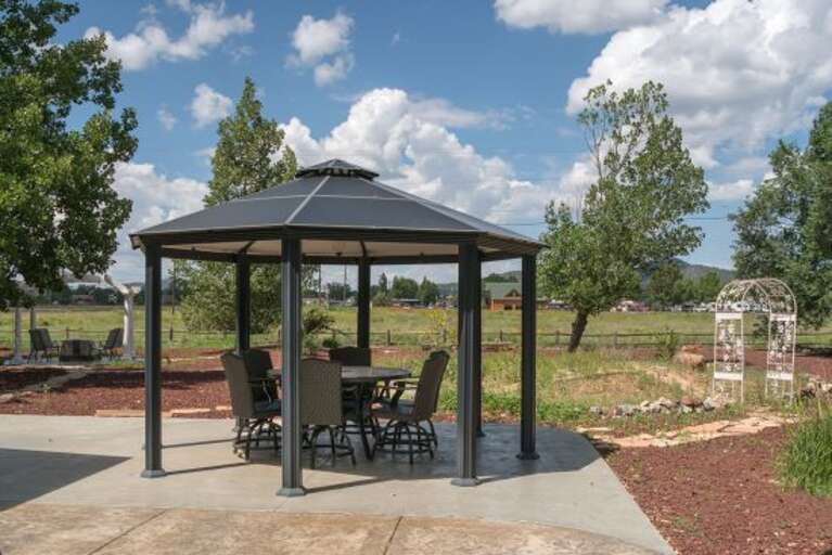 Enjoy outdoor dining with a table for 6 under the backyard gazebo.